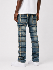 FWRD Patchwork True Stacked Denim jeans in light tint with patchwork design and stacked fit, displayed on a hanger.