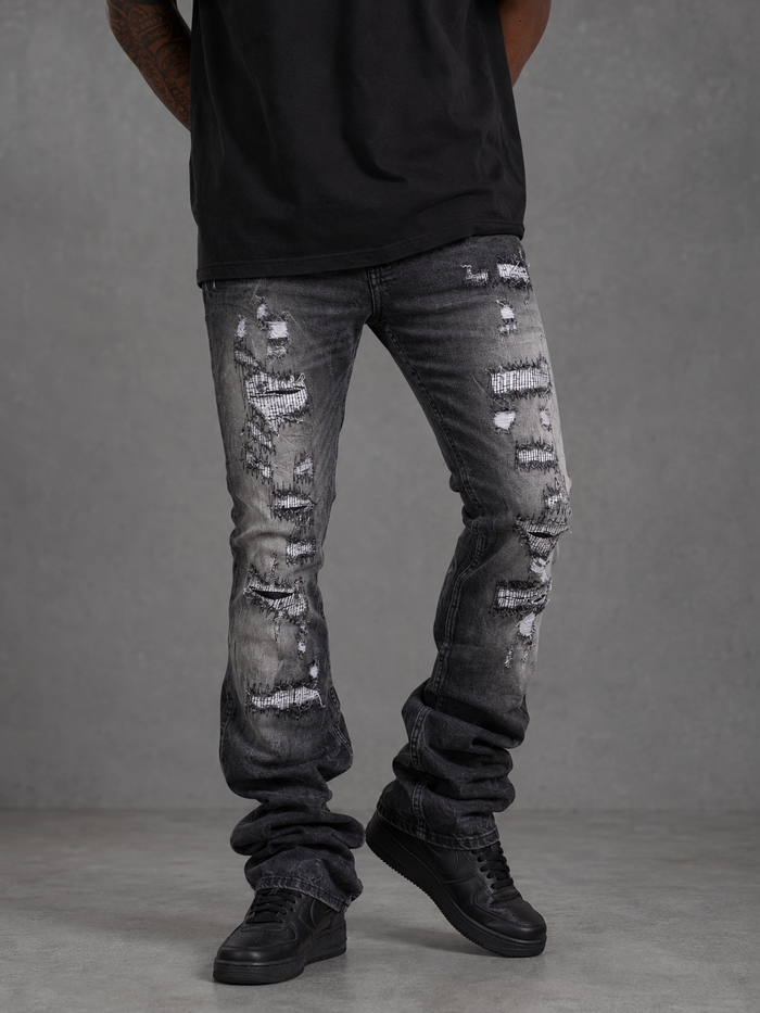 FWRD Worn Down Stacked Flare Denim in washed black, showcasing distressed denim fabric and high-waisted, flared design.