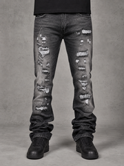 FWRD Worn Down stacked flare denim jeans in washed black with distressed details and frayed hems, displayed on a hanger.