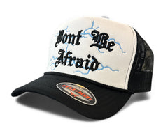 White and black MUKA Don’t Be Afraid trucker hat with mesh back and adjustable strap, casual accessories for streetwear style.