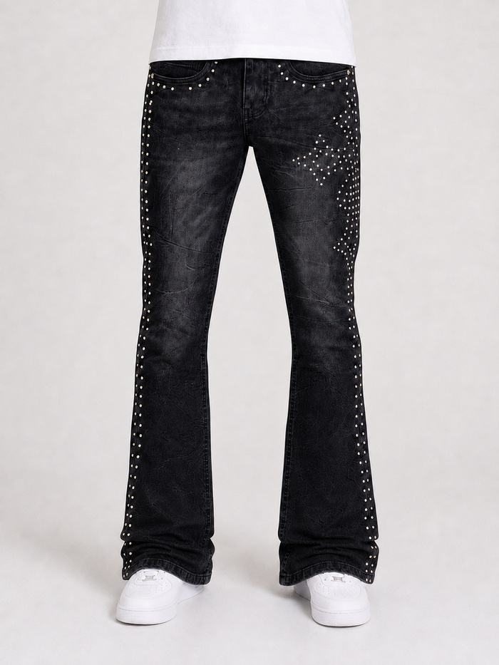 Black denim flared jeans with cross-stud details from Original Fables, featuring a cross-flared leg style and classic denim texture.