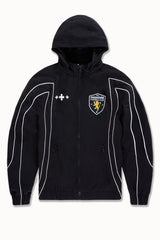 Black SYIP Hooligan Track Jacket with removable hood, featuring sporty design and zip-up front, shown on a model.